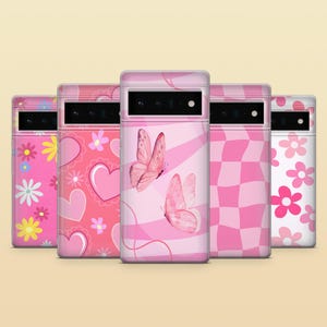 Pode incluir: Cinco capas de telefone cor-de-rosa com diferentes designs. Os designs incluem um padr&atilde;o xadrez rosa e branco, um padr&atilde;o floral rosa e branco, um padr&atilde;o de borboleta rosa e branco, um padr&atilde;o de cora&ccedil;&atilde;o rosa e branco e um padr&atilde;o de linhas onduladas rosa e branco.