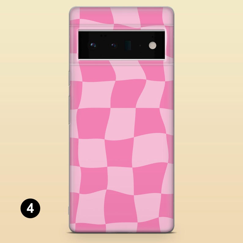 Pode incluir: Uma capa de telefone quadriculada rosa e branca com um padr&atilde;o ondulado. A capa &eacute; projetada para um telefone com um m&oacute;dulo de c&acirc;mera retangular.