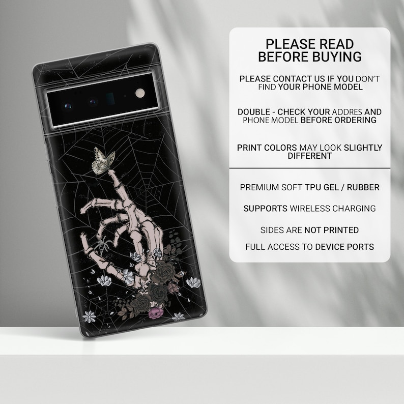 May include: Black phone case with a skeleton hand reaching out to a butterfly on a spiderweb background. The case has a floral design with black, white, and pink flowers. The text "PLEASE READ BEFORE BUYING" is printed on the right side of the image.