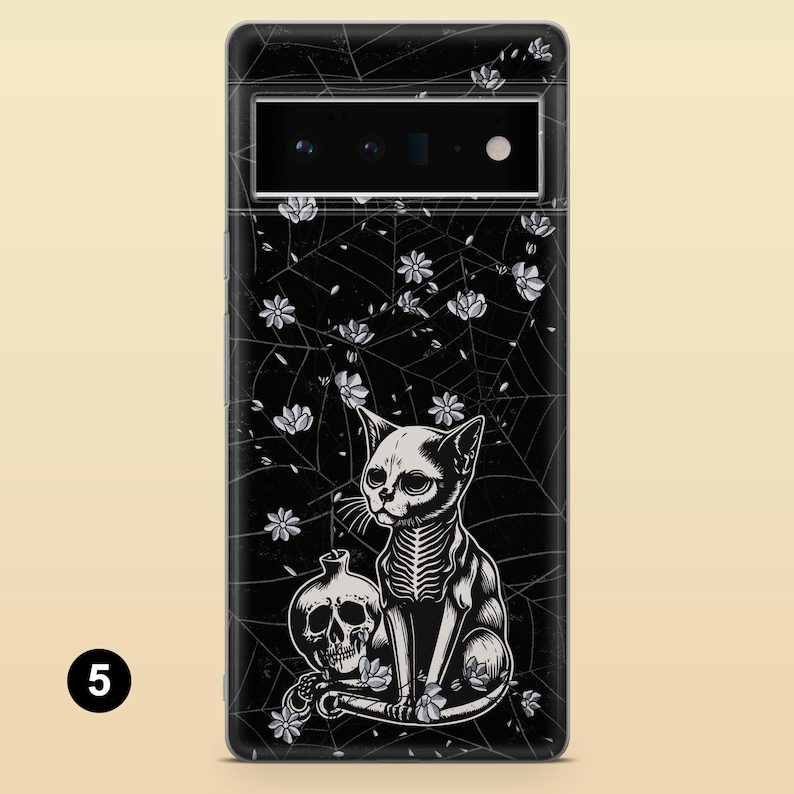 May include: Black phone case with a white skeletal cat design, a skull, and floral accents on a black spiderweb background.