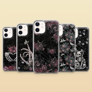 May include: Five clear phone cases with different gothic floral and skeletal designs. The designs include a skeleton hand holding a heart, a skeleton hand holding a butterfly, a spider web with roses, a floral pattern with birds, and a skeleton cat.