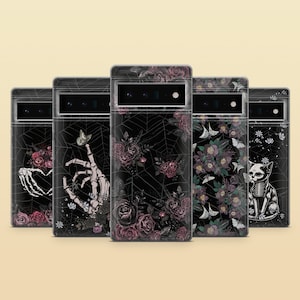 May include: Five clear phone cases with different gothic designs. The designs include a skeleton hand with roses, a skeleton hand with a butterfly, a spiderweb with roses, a floral design with butterflies, and a skeleton cat with flowers.