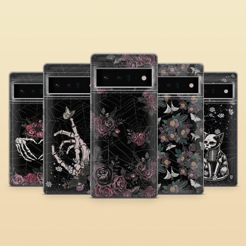 May include: Five clear phone cases with different gothic designs. The designs include a skeleton hand with roses, a skeleton hand with a butterfly, a spiderweb with roses, a floral design with butterflies, and a skeleton cat with flowers.
