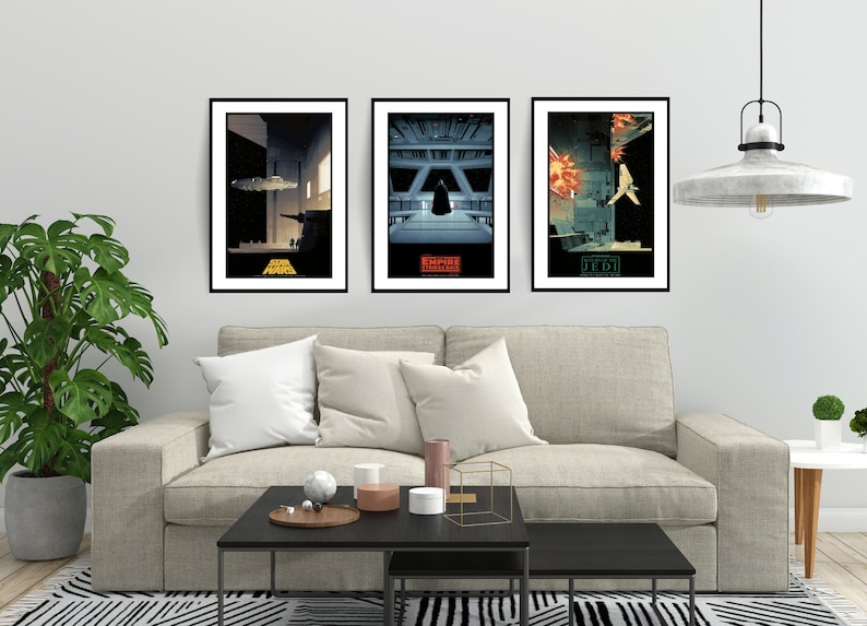 May include: Three framed Star Wars movie posters with minimalist designs. The posters are in black frames and feature the titles "Star Wars", "Empire Strikes Back", and "Return of the Jedi".