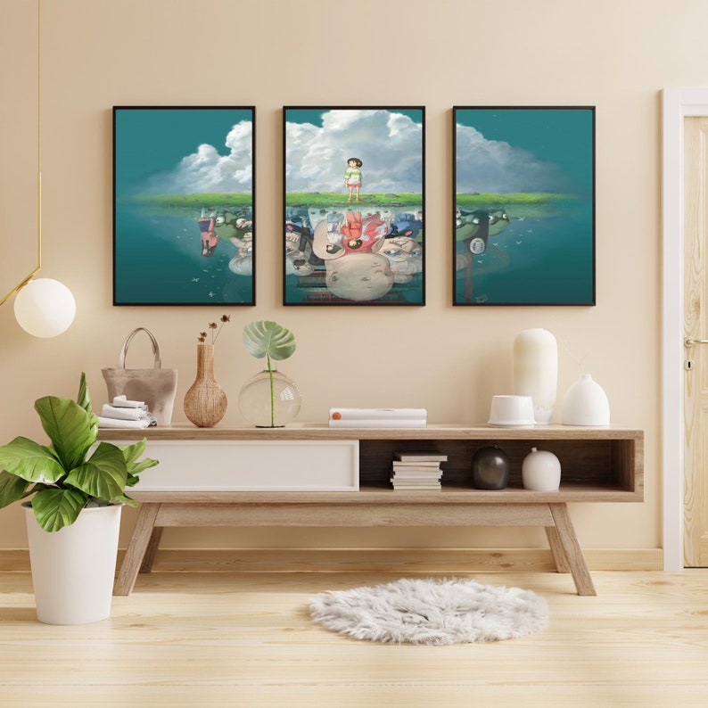 May include: Three framed prints of a scene from the animated film Spirited Away. The middle print shows a young girl standing on a grassy hill with a reflection of the scene below. The reflection shows the girl upside down with other characters from the film.