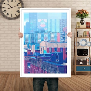 May include: A framed print of a cityscape with a blue and purple color scheme. The buildings are stacked on top of each other and the sky is a light blue. The text "IM BACK" is visible on a billboard in the distance.