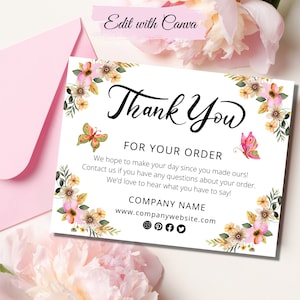 Op de afbeelding: Dankjewel kaart met een bloemenontwerp en vlinders. De kaart zegt "Bedankt voor uw bestelling" en bevat een bedrijfsnaam en een websiteadres.