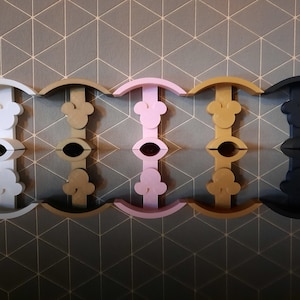Puede incluir: Cinco ganchos de pared de diferentes colores con forma de cabeza de Mickey Mouse. Los ganchos son de color blanco, dorado, rosa, dorado y negro.