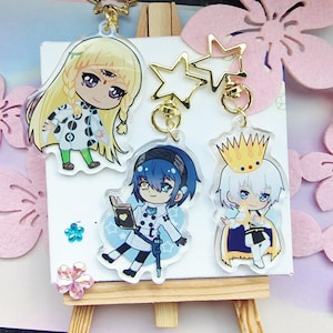 Può includere: Una collezione di portachiavi in acrilico in stile anime. I portachiavi presentano personaggi di cartoni animati colorati con accenti dorati a forma di stella e cerchio. I personaggi hanno capelli biondi, blu e bianchi e indossano vari abiti.