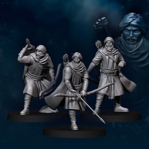 Peut inclure: Trois figurines miniatures grises d'archers, chacune posant avec un arc et une flèche. Ils portent des turbans, des capes et des tuniques. Un buste d'homme avec un turban est en arrière-plan. Les figurines sont sur des socles noirs.