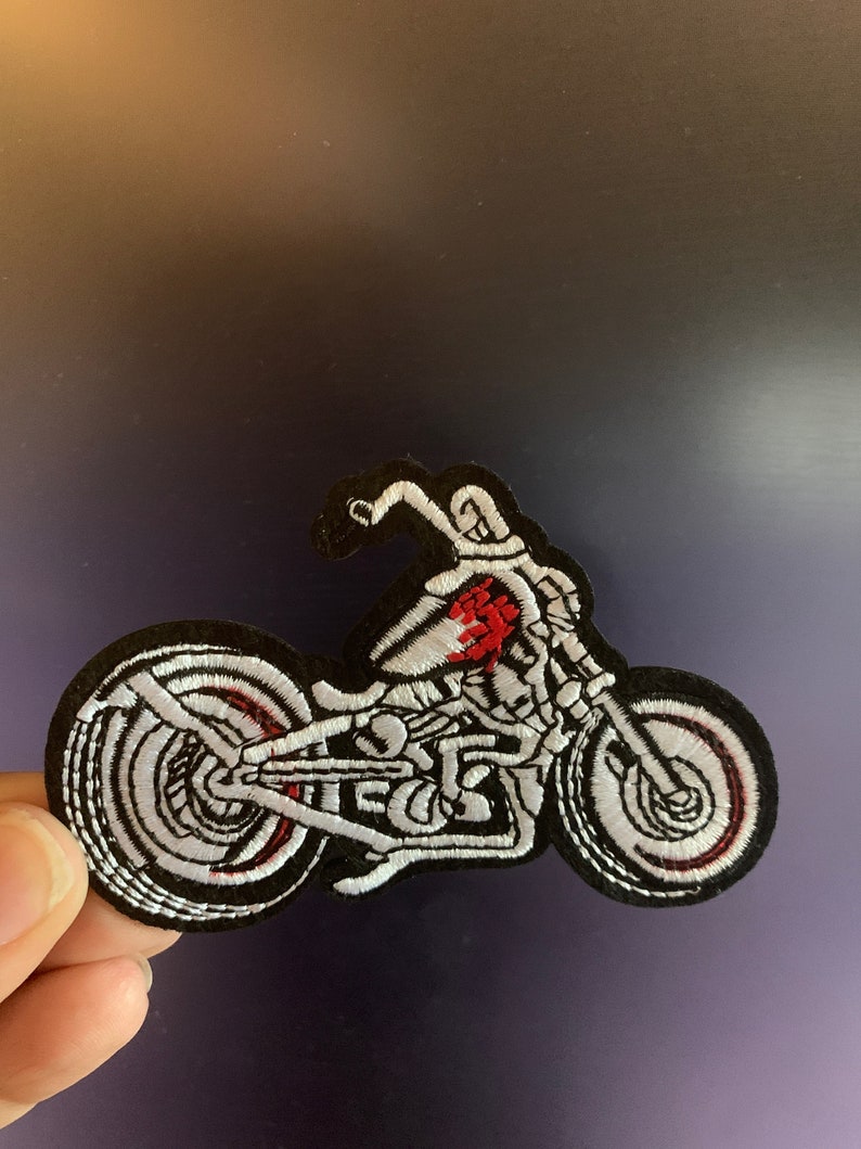 Puede incluir: Parche bordado con un dise&ntilde;o de motocicleta, costuras blancas sobre fondo negro. La motocicleta tiene detalles en rojo y radios detallados. Adecuado para chaquetas, bolsos u otros art&iacute;culos de tela.