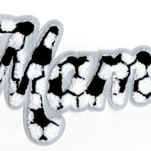 May include: A white and black soccer ball patterned iron-on patch that spells out the word "Mom".