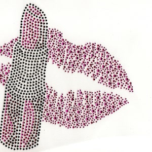 May include: A rhinestone design of a mouth and tongue, with the tongue extended. The lips and tongue are made of pink rhinestones, while the outline of the tongue is black. The design is on a white mesh background.