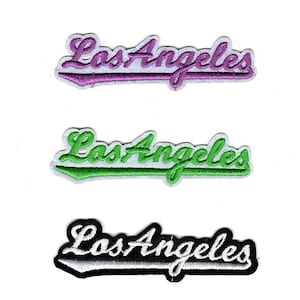 May include: Five embroidered patches with the text "Los Angeles" in different colors. The patches are white with a black outline and the text is in blue, purple, green, white, and gold.