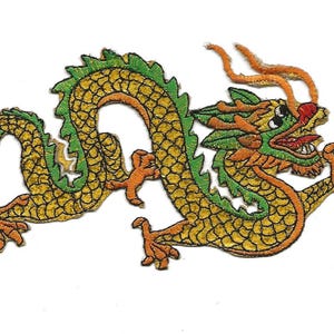 May include: A yellow and green embroidered dragon with orange accents. The dragon is curled up with its head facing the right side of the image.