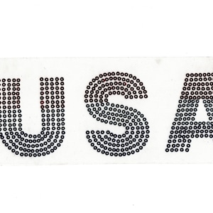May include: USA spelled out in black and red sequins on a white background.