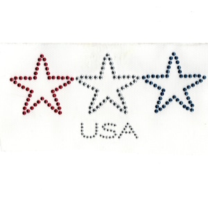 May include: Three stars in red, silver, and blue with rhinestones, with the word "USA" in silver rhinestones below.