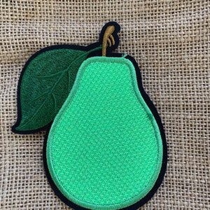 May include: Green pear-shaped embroidered patch with a green leaf and a brown stem. The patch has a black outline and is on a brown burlap background.