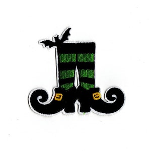 May include: Black and green witch's boots with a pointed toe and a curled heel. A black bat is above the boots.