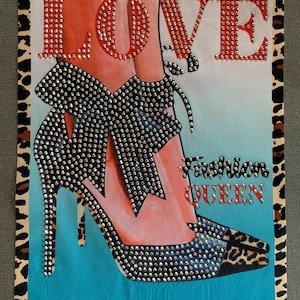 May include: A colorful graphic print with the word "LOVE" in red rhinestones, featuring a pair of high-heeled shoes with a black bow and a leopard print design. The text "Fashion Queen" is printed in black below the shoes.