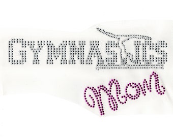 May include: Iron-on rhinestone design featuring the words "Gymnastics Mom" with a pink ribbon and a silver gymnastics bar.