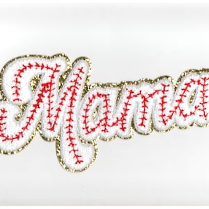 May include: White felt applique with the word "Mama" in gold glitter lettering with red stitching that resembles a baseball stitch.