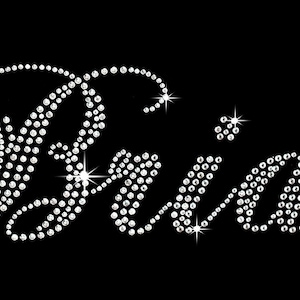 May include: The word "Bride" spelled out in sparkling rhinestones. The letters are in a cursive font and have a glittery effect.