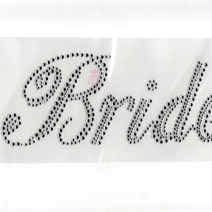 May include: A white background with the word "Bride" spelled out in black rhinestones.