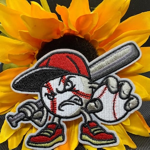 May include: Embroidered baseball patch featuring a baseball character with a red cap, holding a bat and a baseball. The patch has a white background with red and black accents, and is set against a yellow sunflower.