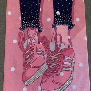 May include: Pink sneakers with white laces and white stripes, covered in rhinestones, on a pink background with white polka dots.