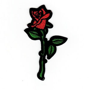 May include: A red rose with a green stem and leaves. The rose is embroidered on a black fabric.
