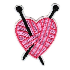 May include: Embroidered patch featuring a pink heart filled with yarn, pierced by two black knitting needles. The heart and needles are outlined in white. This patch is perfect for crafters and those who love knitting.