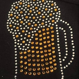 May include: A black fabric patch with a gold and silver rhinestone design of a beer mug.