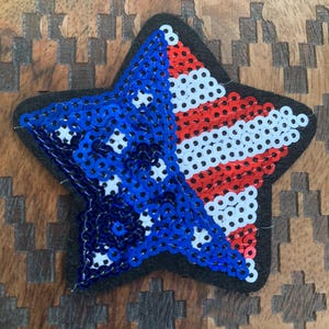 May include: A star-shaped patch with red, white, and blue sequins, resembling the American flag.