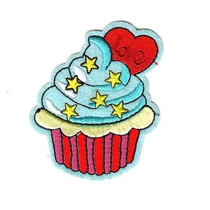 May include: A blue and yellow cupcake with a red heart on top. The heart has the word "love" written on it. The cupcake is decorated with yellow stars.