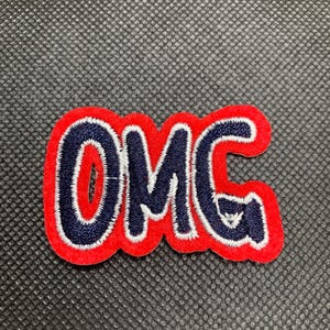 May include: Red and blue embroidered patch with the word "OMG" in white lettering.