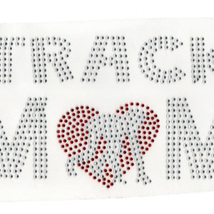 May include: Iron-on rhinestone design featuring the words "TRACK MOM" with a red rhinestone heart in the center.