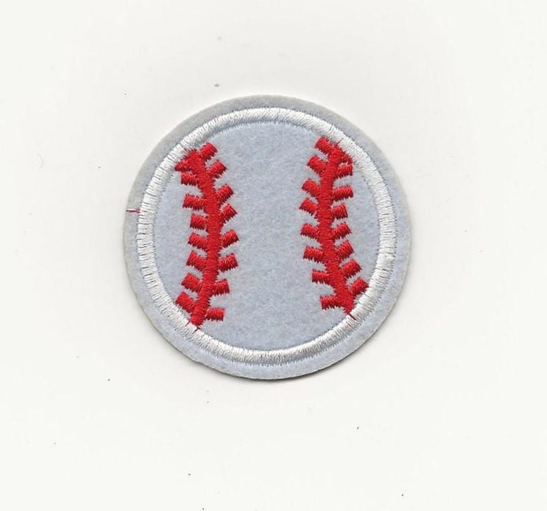 May include: A round baseball patch with a light gray background and red stitching details. The patch has a white border and is designed to resemble a baseball. Ideal for sports enthusiasts.