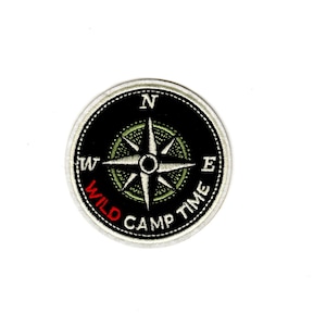 May include: A black and white embroidered patch with a compass design and the text "WILD CAMP TIME" in white with the word "WILD" in red.