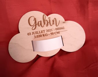 Puede incluir: Una placa de madera en forma de nube con el nombre "Gabin" grabado en ella. La placa también incluye la fecha "03 Juillet 2021 - 00H42" y las medidas "3.030 KG - 50 CM".