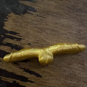 Könnte beinhalten: Eine goldfarbene, 3D-gedruckte, abstrakte Skulptur mit einer glatten, glänzenden Oberfläche.