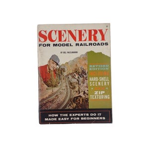 May include: A vintage book cover with a red title "SCENERY FOR MODEL RAILROADS" by Bill McClanahan. The cover features a photo of a model railroad with a man in a red shirt and a white hat. The book is a revised edition including hard-shell scenery and zip texturing.