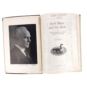 May include: An open book with a black and white portrait of a man on the left page and text on the right page. The text reads "Jack Miner and the Birds" and "Some Things I Know About Nature". A drawing of a goose is below the text.