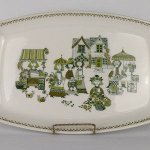 May include: A white rectangular serving platter with a green and brown design of people shopping at a market. The design includes a house, a fishmonger, a flower vendor, and a fruit vendor.