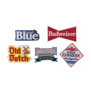 Könnte beinhalten: Eine Sammlung von fünf gestickten Aufnähern mit verschiedenen Biermarken-Logos. Die Aufnäher zeigen Labatt Blue, Budweiser, Old Dutch mit einer Windmühle, Northern Breweries mit dem Text Best of the Pack und einen rautenförmigen Molson Canadian Aufnäher.