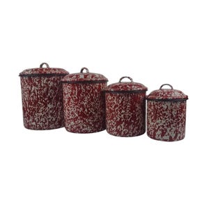 May include: Set of four red and white speckled enamel canisters with lids. The canisters are different sizes and are arranged in a row from largest to smallest.