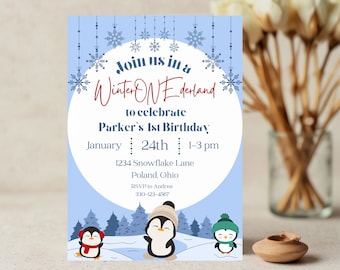 May include: A blue and white invitation card with snowflakes and penguins. The text reads "Join us in a Winter ONEderland to celebrate Parker's 1st Birthday. January 24th 1-3 pm 1234 Snowflake Lane Poland, Ohio RSVP to Andrea 330-123-4567"