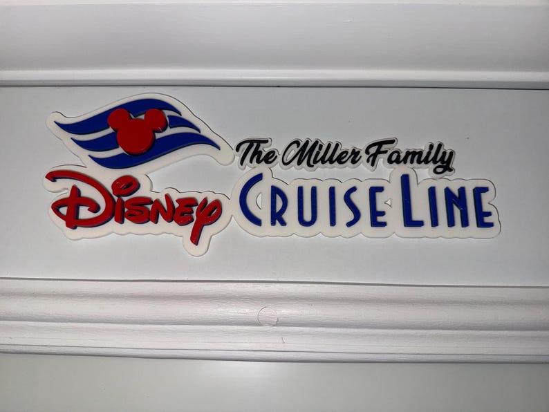 May include: White sign with the text "The Miller Family Disney Cruise Line" in black and blue lettering. The Disney Cruise Line logo is a red Mickey Mouse head on a blue and white wave.