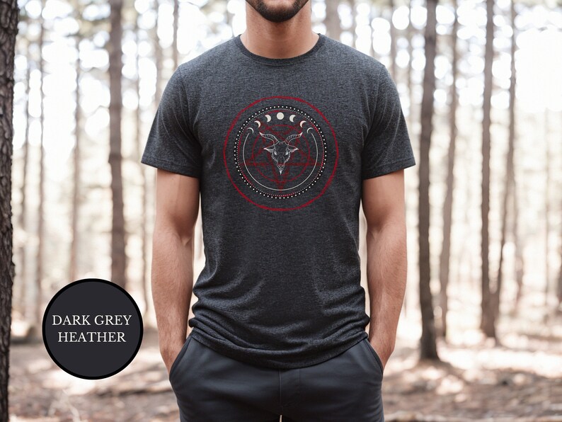 May include: A dark grey heather t-shirt with a graphic of a goat's head inside a circle with moons and stars.