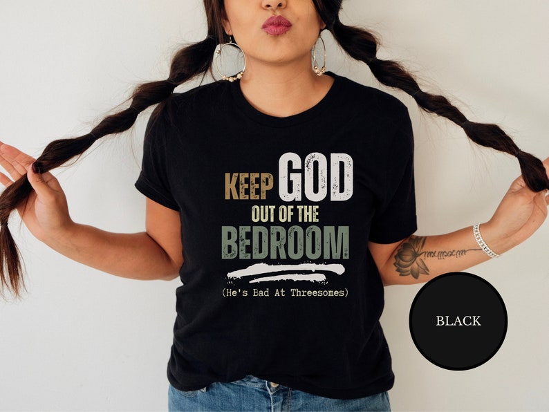female wiccan witch wearing a Black short sleeve antireligion shirt that says Keep God Out Of The Bed Room - He's Bad At Threeways - Funny pagan blashemous shirt